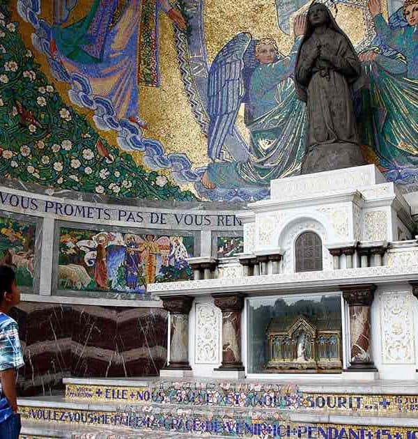 child praying at lourdes pilgrimage tour